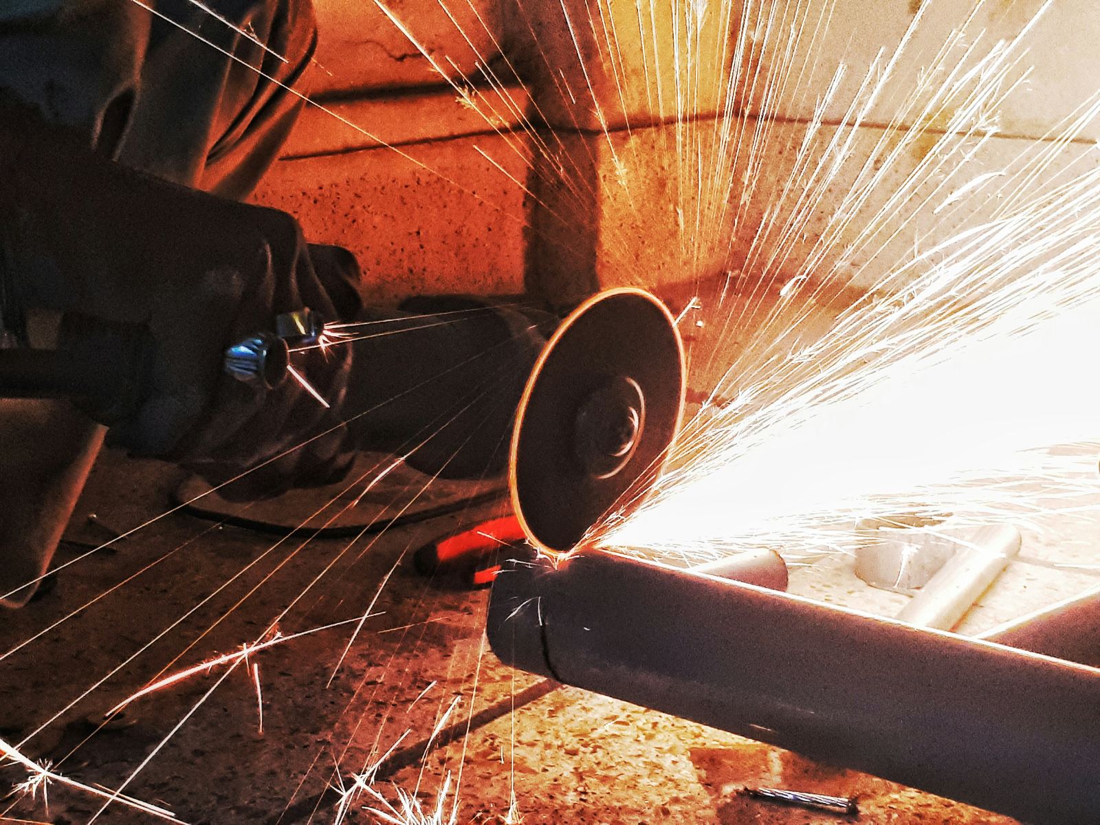 Pipe cutting with sparks on a job site
