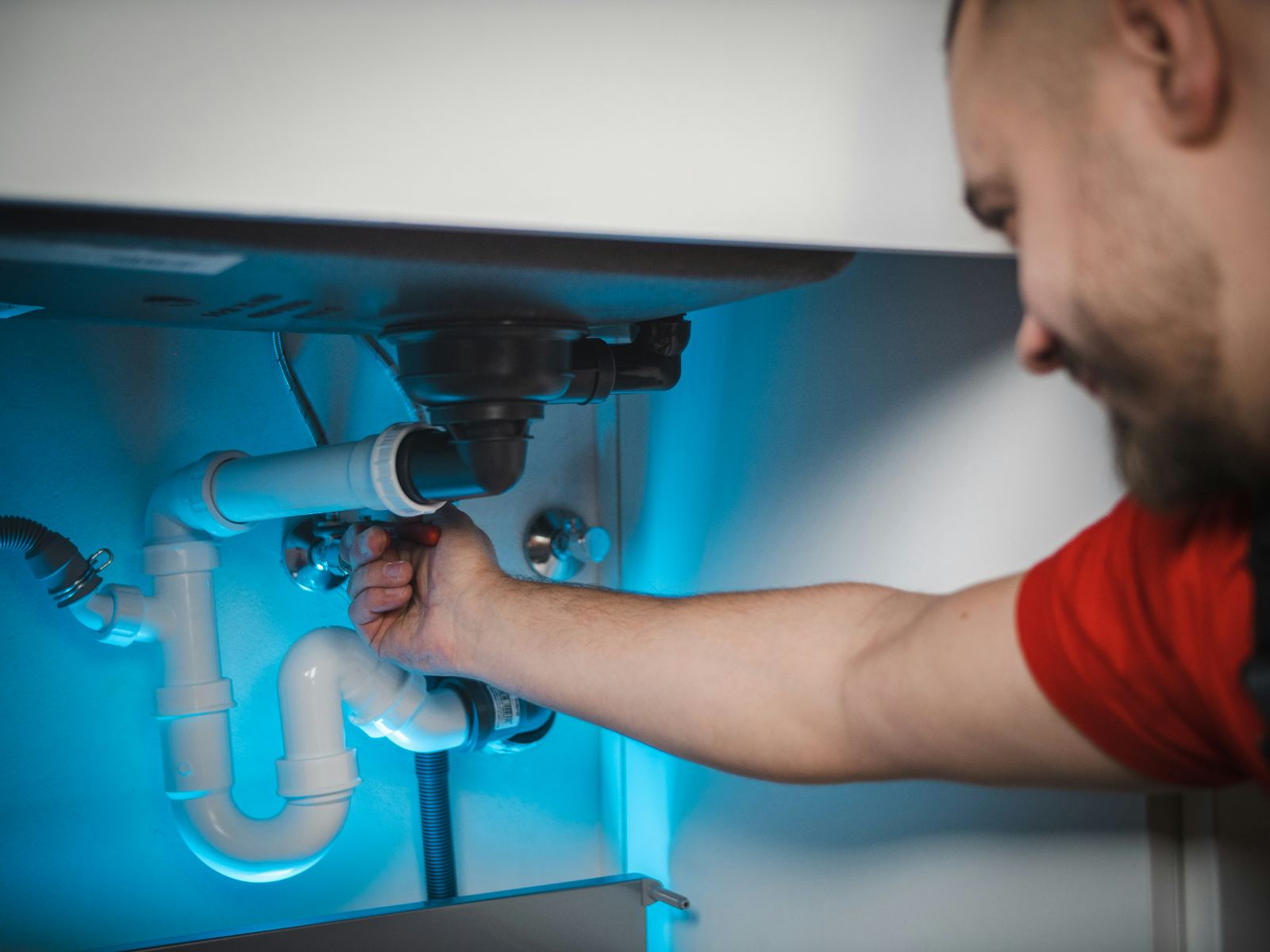 Plumber servicing an under-sink drain